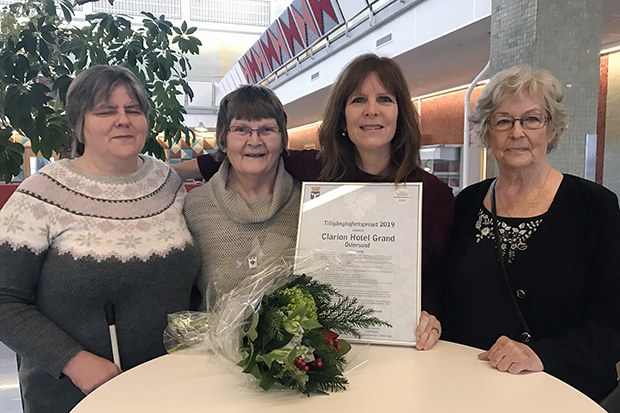 Fyra kvinnor med diplom och blommor efter prisutdelningen.