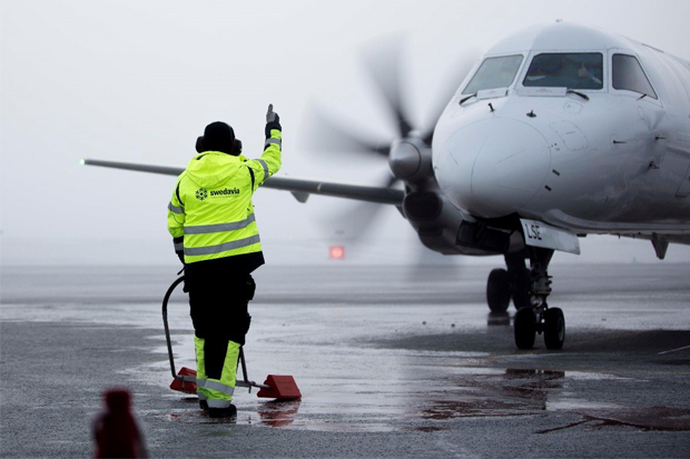 Bild på ett flygplan och markpersonal