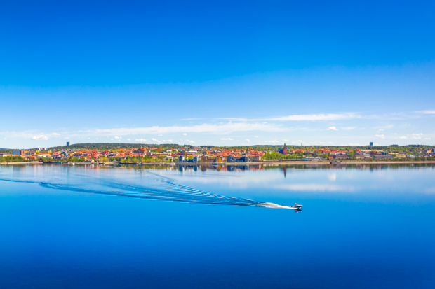 Bild på storsjön sommartid en vit båt syns körandes