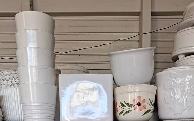 Vita keramikkrukor. Vissa i mönster. En med blommor i pastell.