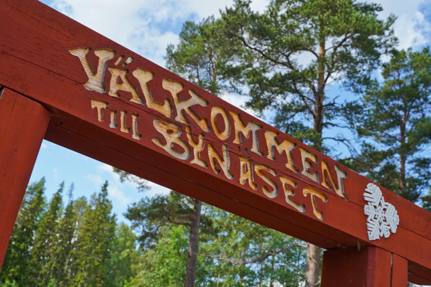 Bild på röd träentré med texten "Välkommen till Bynäset" med ett vitt Östersundshjärta bredvid.