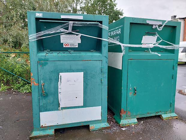 Gröna conatinrar för klädinsamling med tejp runt om.