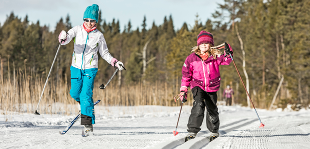 Två barn åker längdskidor