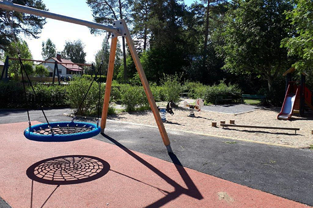 En lekplats med lekredskap, i förgrunden en kompisgunga