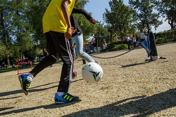 Bild på två barn som spelar fotboll i Badhusparken.