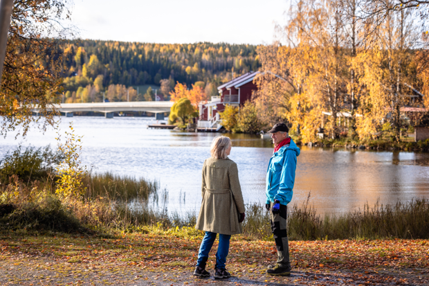 Två människor på promenad i höstlandskap.
