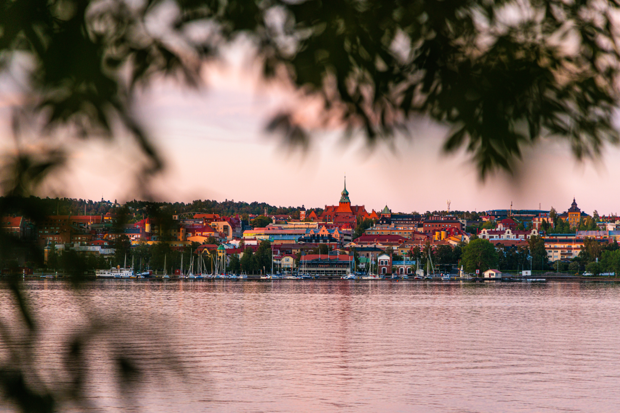 Vy över Östersund fotat med löv och Storsjön i förgrunden