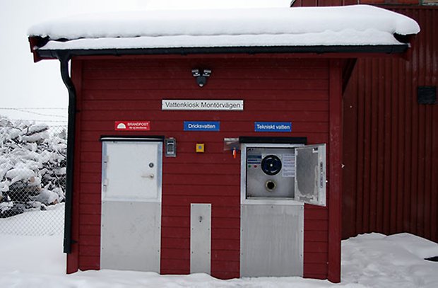 En vattenkiosk - liten rödmålad byggnad där företagare kan hämta vatten