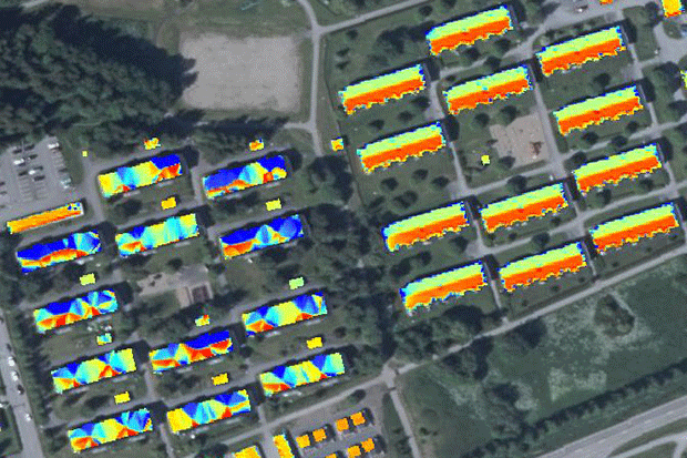 Flygbild över ett bostadsområde med färgade rutor över taken, vissa melerade i alla färger och vissa gula och gröna.