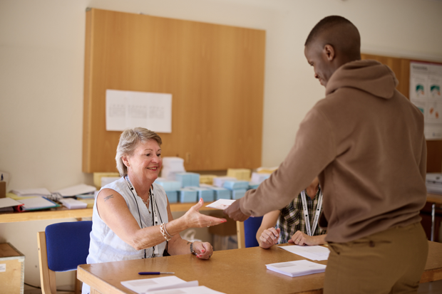 Valarbetare tar emot röst från ung man