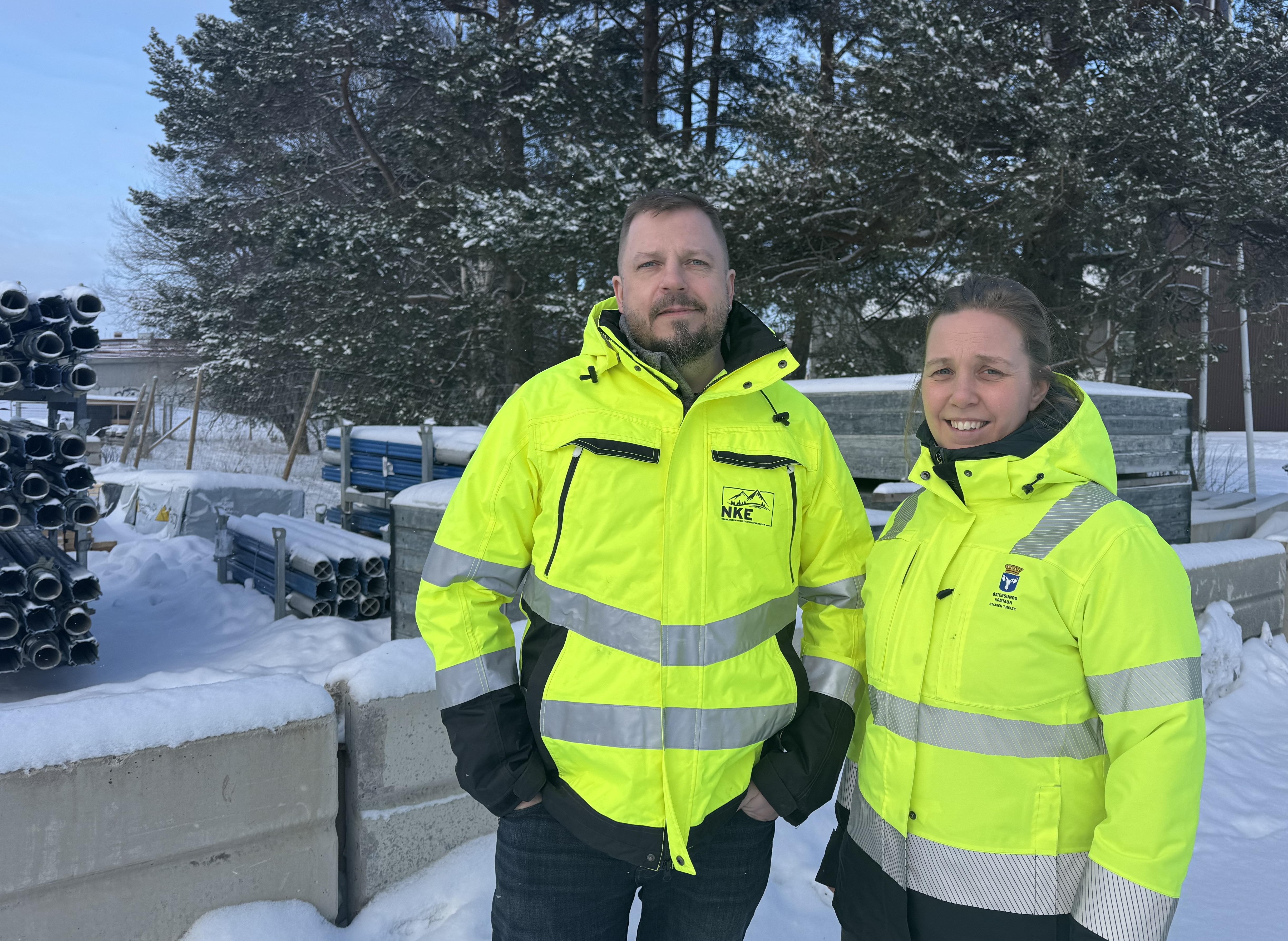 En man och en kvinna klädda i varselkläder som ler mot kameran.