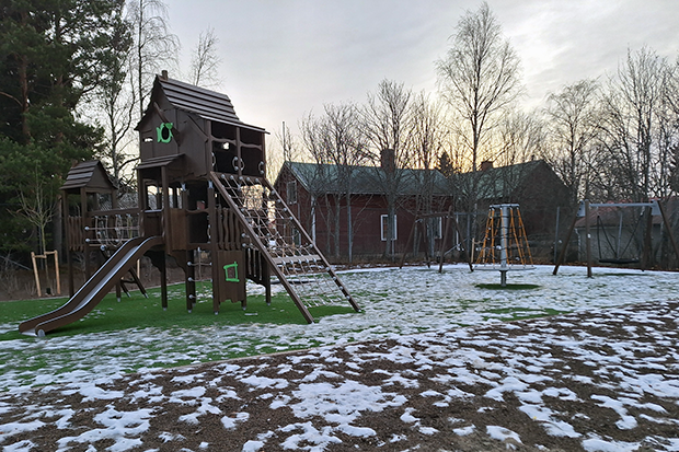 En lekplats i nysnö och kvällsljus