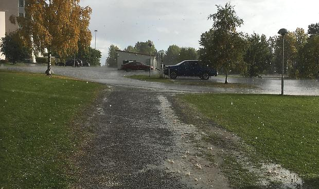 regn som studsar i vattenpöl och på parkering, hagel