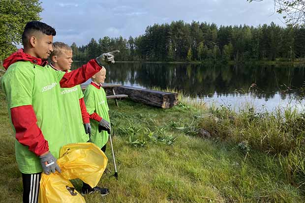 Pojkar som blickar ut över vattendrag vid Älvstädningen.