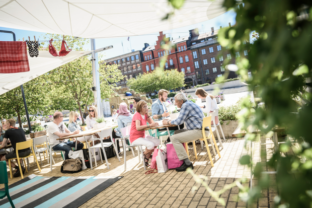 Arkivbild från en uterestaurang på stan där en familj sitter och äter i finvädret.