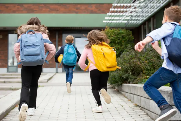 skolbarn som springer mot skolan