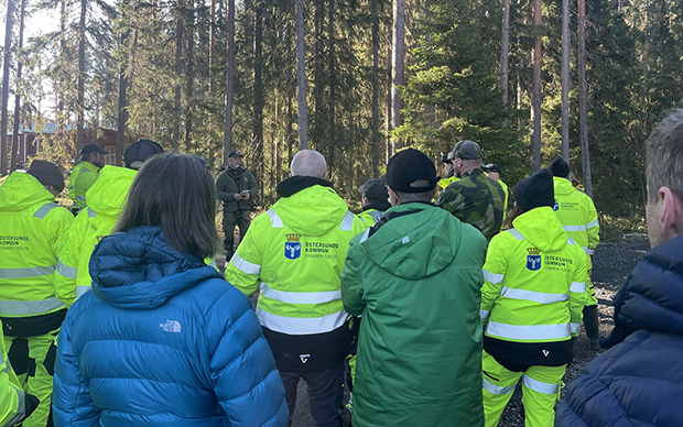 Ryggar på en grupp människor i skogen.