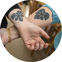 Två underarmar i kors med tatueringar i form av Östersundshjärtat