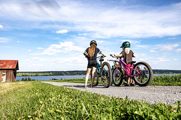 två barn som cyklar på grusväg