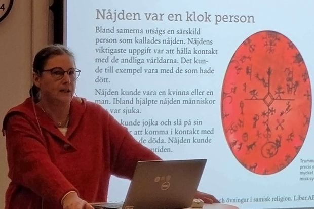 bild på kvinna när hon undervisar. I bakgrunden en presentation som visar information om samiska kulturen