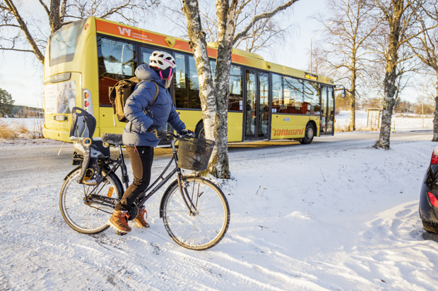 Foto: En vintertrampare med en buss i bakgrunden