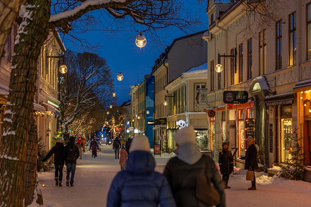 Vinterskymning över gågatan där människor går och gatubelysningen är tänd