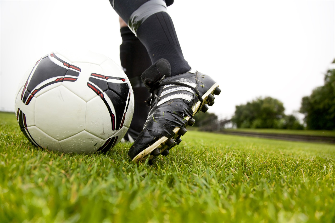 Bilden föreställer en fotbollsspelares fot iförd fotbolsskor.