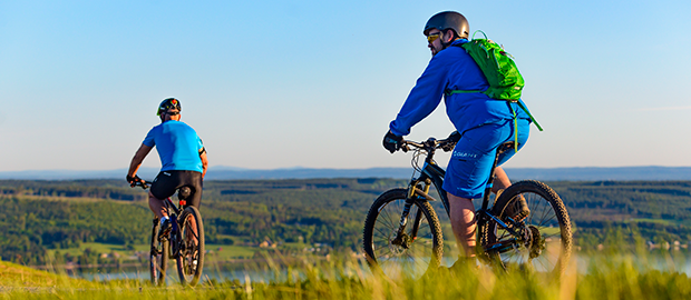 Cyklist som cyklar över gång och cykelbron från Frösön till Östersund en tidig vårdag.