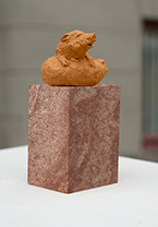 Staty i brun lera på två kultingar som ligger tätt intill varandra i en ring.