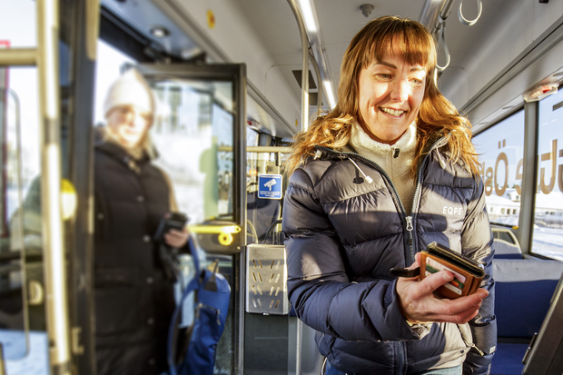 Kvinna som blippar en biljett på buss 