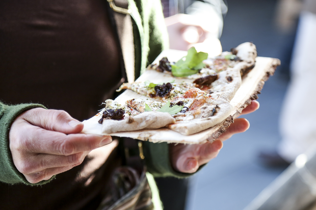 Händer som håller i ett fat med pizza bitar under UCCN konferensen 2016.