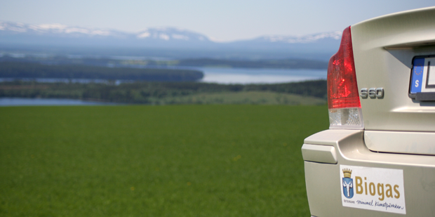 Baklyktorna på biogasbil i förgrunden och utsikt över fjällen i bakgrund