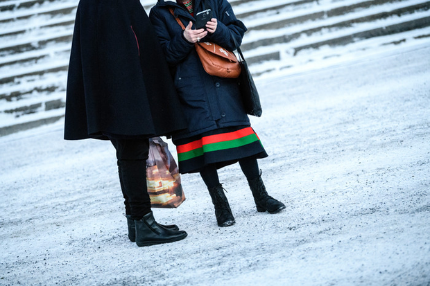 Två personer, en i svart jacka och en i samisk dräkt.