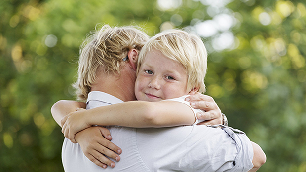 man som kramar om en liten pojke