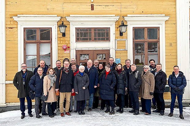 Gruppbild med anställda från de två norska kommunerna och Östersunds kommun framför ett gult hus