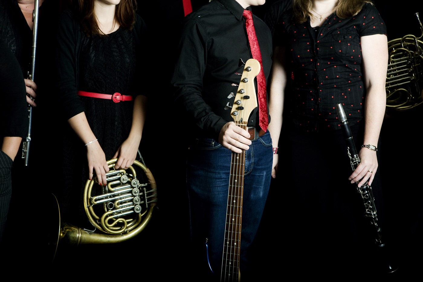 Bilden föreställer några medlemmar ur en musikensemble som håller sina instrument i sina händer.