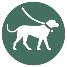 Rund mörkgrön skylt med piktogram för hund.