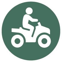 Rund mörkgrön skylt med piktogram för fyrhjuling.