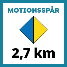 Skylt för motionsspår på 2,7 km med tvåfärgad romb i blått och gult. Färgerna indikerar dels längden på spåret samt att spåret har belysning.