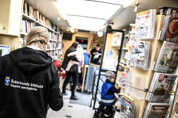 Vuxna och barn inne i biblioteksbussen