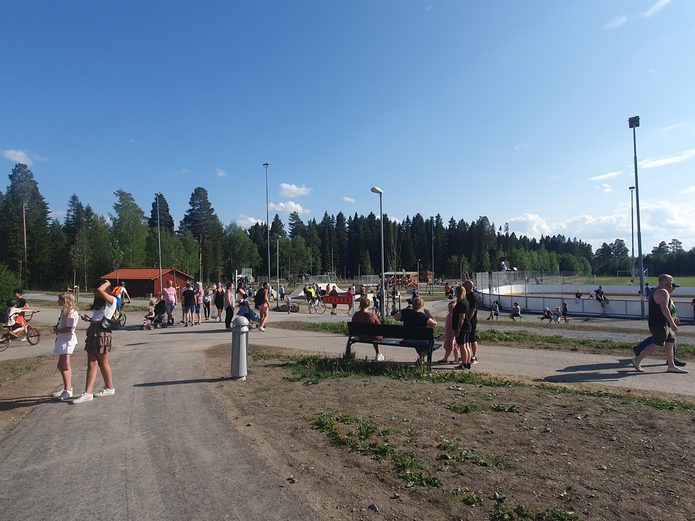 Blå himmel och människor som samlas för att fira invigningen av Torvallas nya aktivitetscenter. 