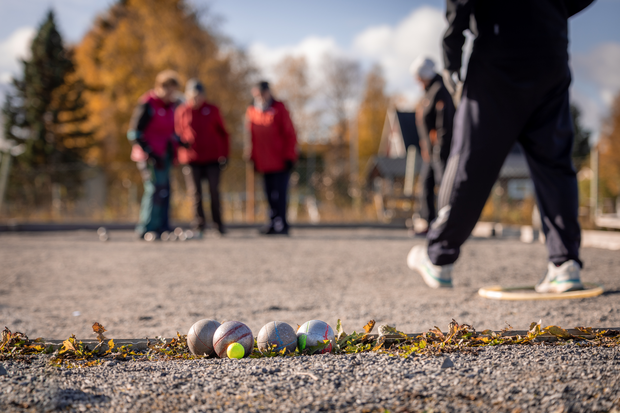 Personer spelar boule på grusplan