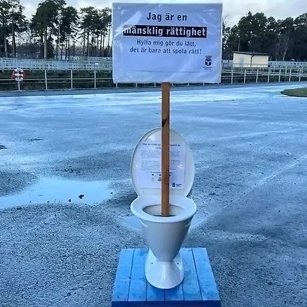 Toalett med protestskylt: Jag är en mänsklig rättighet, hylla mig gör du lätt det är bara att spola rätt!