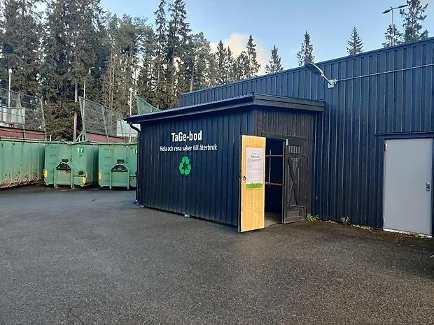 Ett svart hus där det står TaGe-bod på