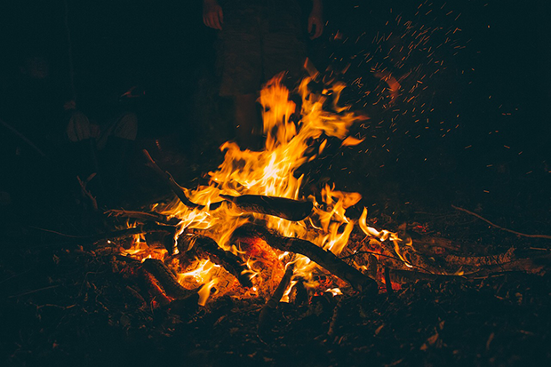 En värmande brasa där människor skymtar i bakgrunden