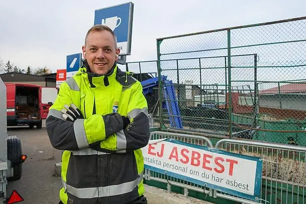 Robin Pettersson framför en container med en skylt som lyder "ej asbest" med stora röda bokstäver