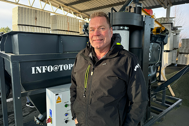 Kjell Sundholm poserar framför sin egen uppfinning, maskinen som renar granulat.