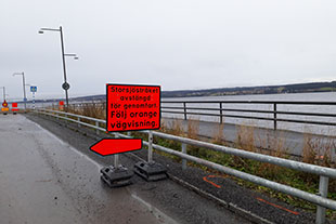 Orange vägtrafikskylt som hänvisar gångtrafikanter