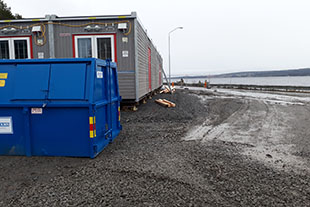 Blå container och grå byggbaracker