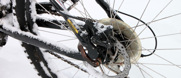 Närbild på bakhjulet på en cykel, stående i snön